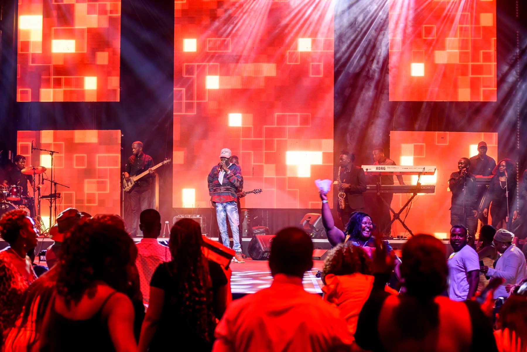 Concert crowd enjoying a live performance beneath red lighting