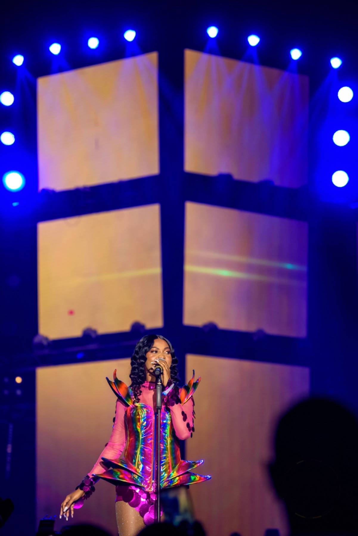 Singer performing beneath neon blue stage lighting
