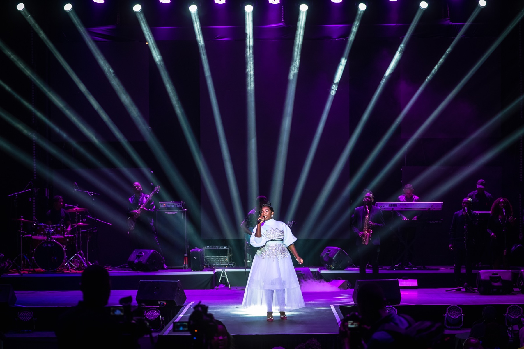 Singer performing beneath dramatic concert spotlights
