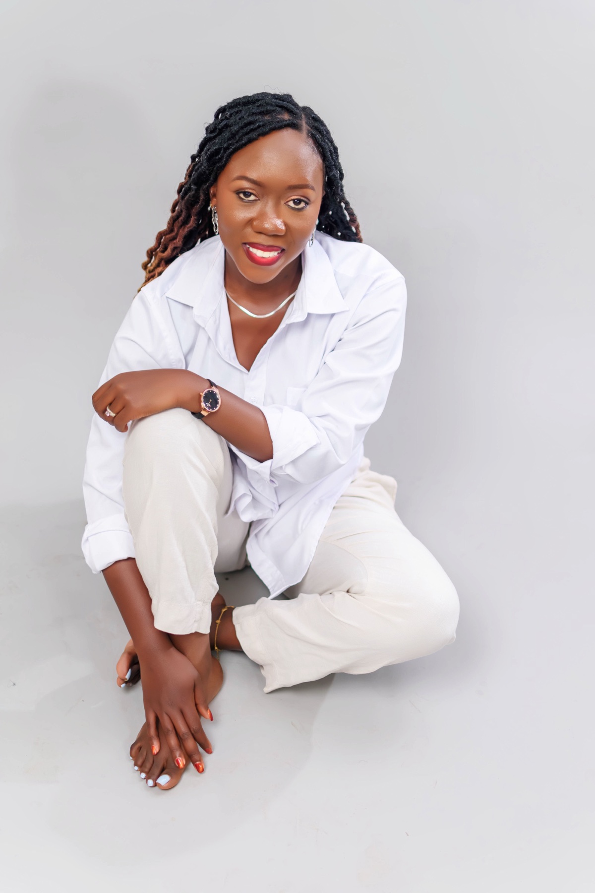 Woman seated in a white outfit for a studio portrait