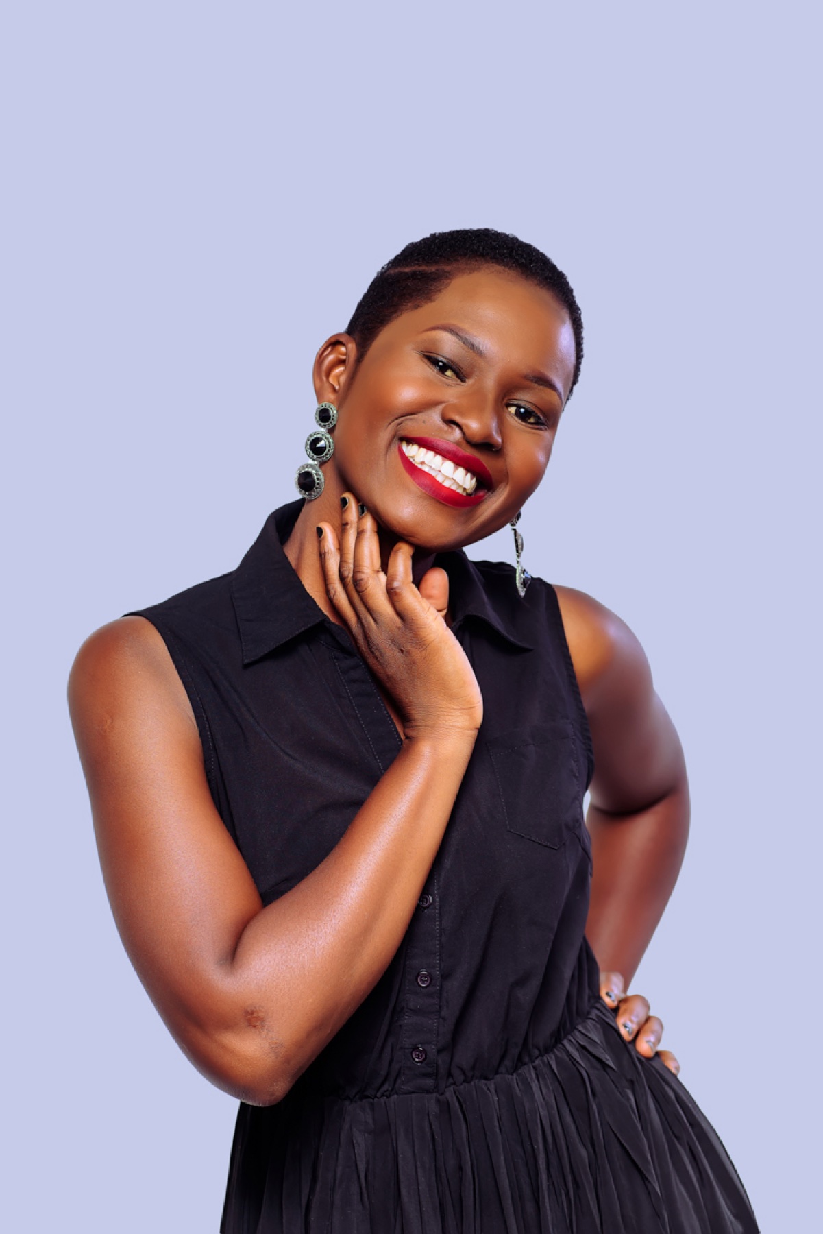 Smiling woman in a black dress against a light studio background