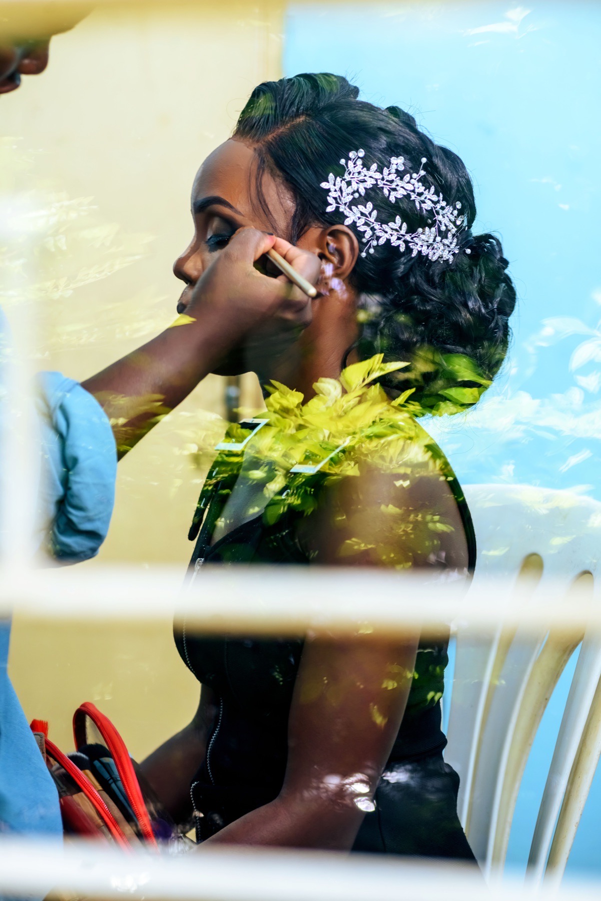 Bride having her makeup applied before her wedding celebration