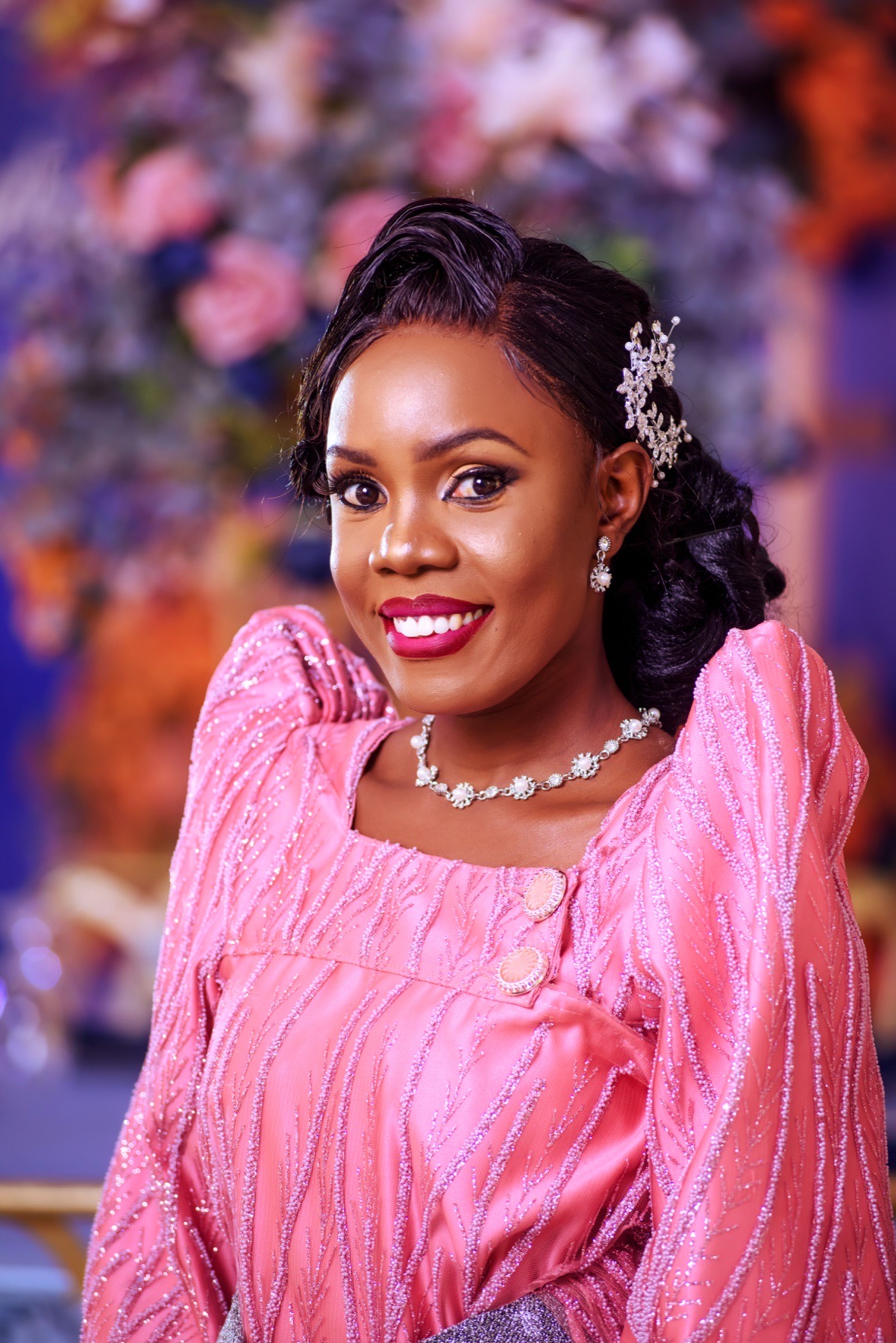 Bride in a pink ceremonial dress smiling for a wedding portrait