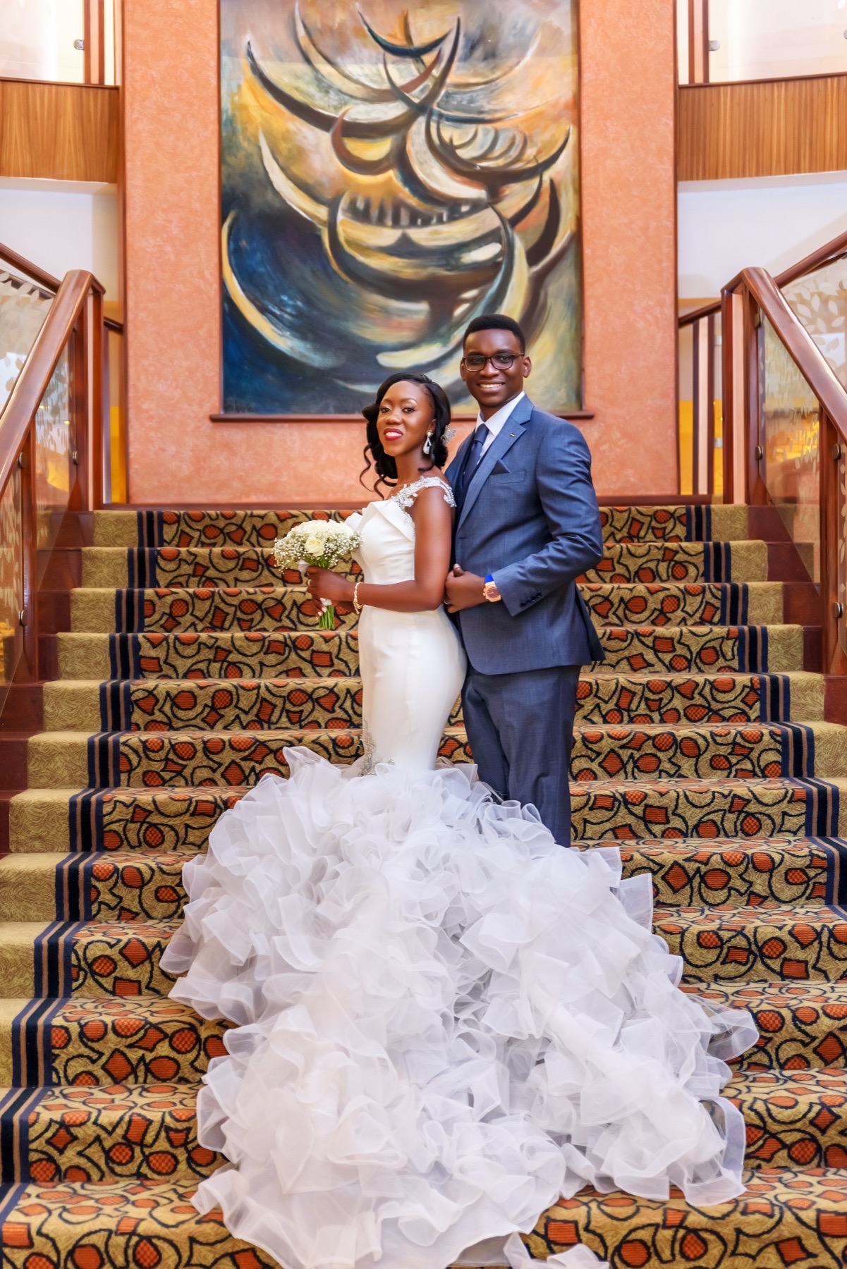 Bride and groom posed together on a grand staircase