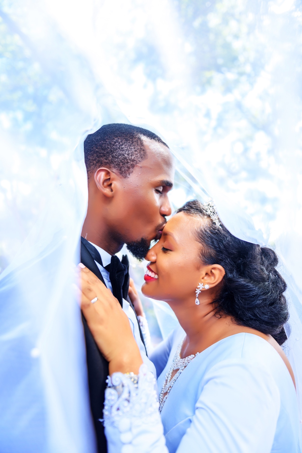 Groom kissing the bride beneath her veil