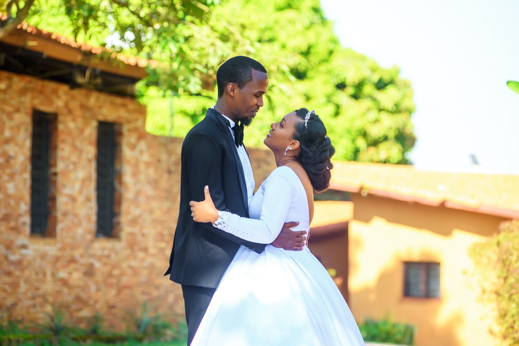 Bride and groom embracing in a sunlit outdoor portrait
